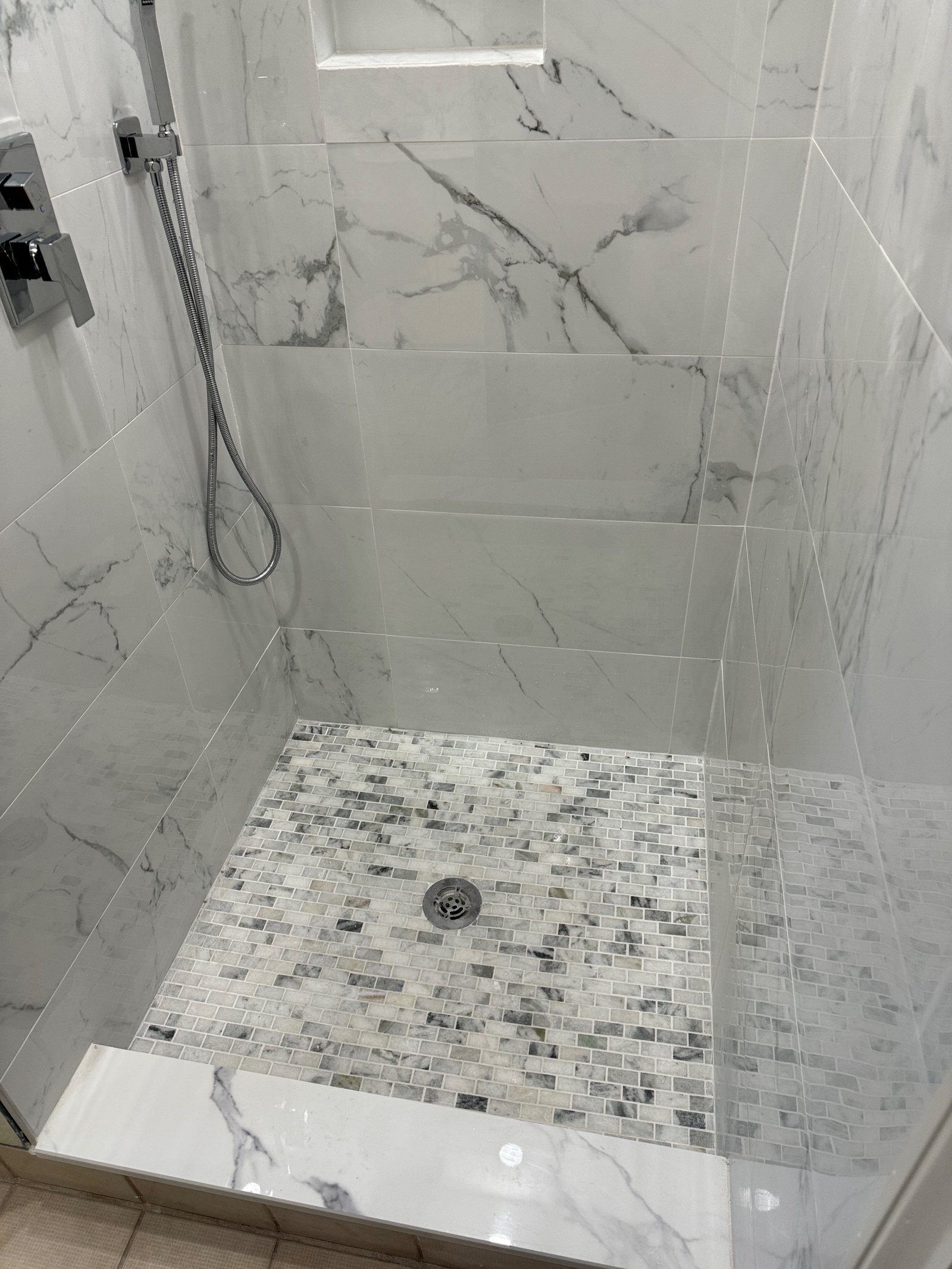 A rebuilt tiled shower with the mixer running