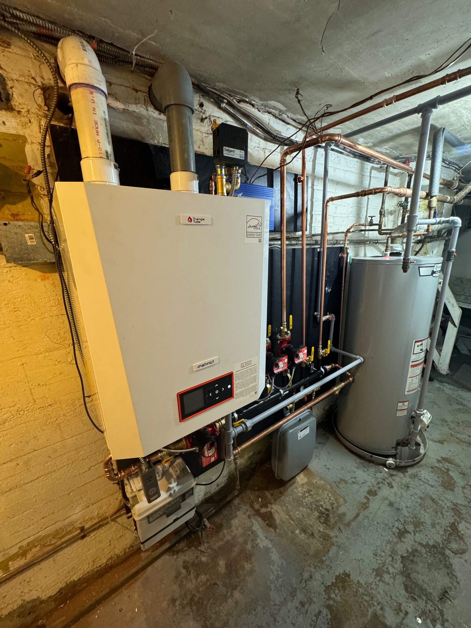 Two tankless units mounted beside a storage cylinder
