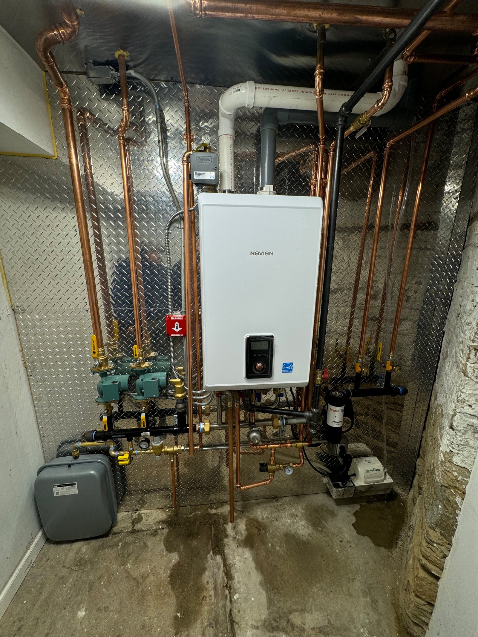 A finished boiler room with labelled valves and copper pipework